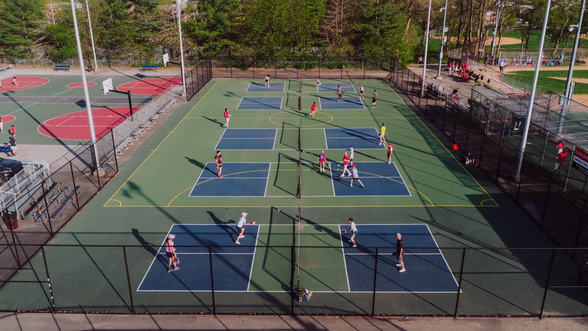 Two beginners rallying on an outdoor pickleball court